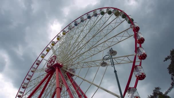 Rueda Fortuna Roja Girando Lentamente Sobre Fondo Nubes Tormenta Gris — Vídeo de stock