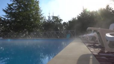 Beyaz sabah sis tabakası havuzun üzerinde hareket ediyor.