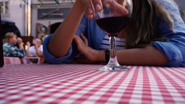 Mãos femininas levantando o copo de vinho tinto — Vídeo de Stock