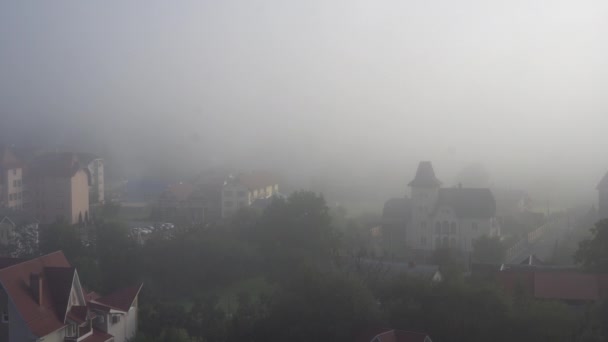 Τα σπίτια αχνά ξεπρόβαλε μέσα από την ομιχλώδη ομίχλη — Αρχείο Βίντεο