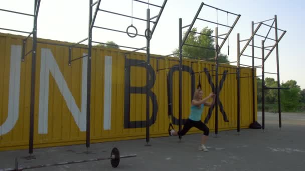 Atractiva mujer haciendo sentadilla en el gimnasio al aire libre — Vídeos de Stock