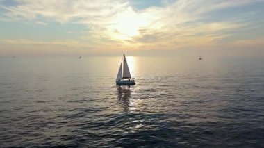 Sakin sularda süzülen bir kayıkla çarpıcı bir günbatımına karşı sakin bir yelken sahnesi, ihtişamlı doğalar sergiliyor. Sakin sularda gün batımı macerasının nefes kesici güzelliğini tecrübe et.