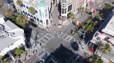 Beverly Hills, California 'daki Dayton Yolu ve Rodeo Drive' daki ikonik kavşağı gösteren hava görüntüleri. Görünürde palmiye ağaçları, yayalar ve lüks mağazalar var. Yüksek kalitede olanlar da dahil.
