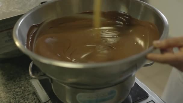 Vloeibare chocolade in een kom voor de vervaardiging van snoep — Stockvideo