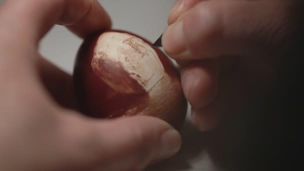 Люди прикрашають яєчний візерунок, дряпаючи його — стокове відео