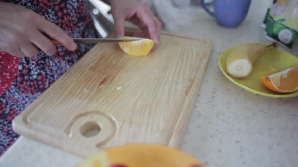女性の手がオレンジをカット — ストック動画