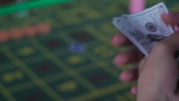 Flicka med en bunt med pengar på att spela roulette — Stockvideo
