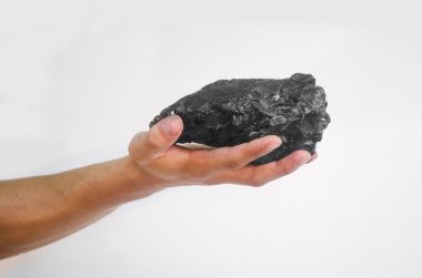 Beyaz arka plan üzerinde kömür parçası tutan erkek el