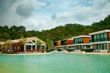 Yüzmek ve dinlenmek için rahat bir yüzme havuzu, otelin mavi suyuyla, bir yaz günü.