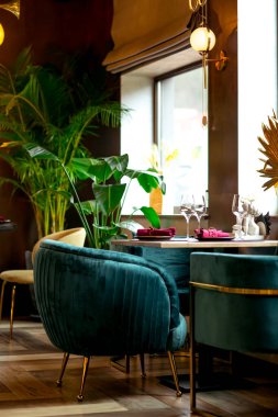 Restoranda güzel ve şık bir iç mekan, masa düzeniyle, tabaklar ve mobilyalarla.