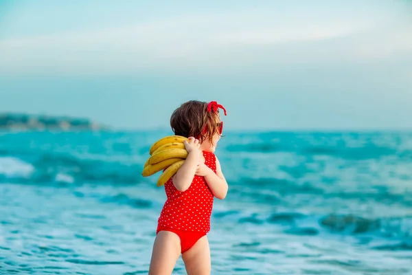 Een Klein Meisje Een Rood Badpak Een Zonnebril Blootsvoets Het — Stockfoto