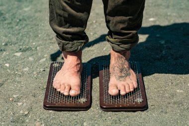 Sochi, Rusya, 05.03.2021 dövmeli yakışıklı bir erkek yogi sadhu tahtasında çivili duruyor.