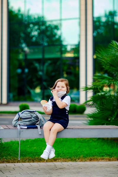 Una Colegiala Cerca Escuela Sienta Banco Come Sándwich Una Máscara — Foto de Stock