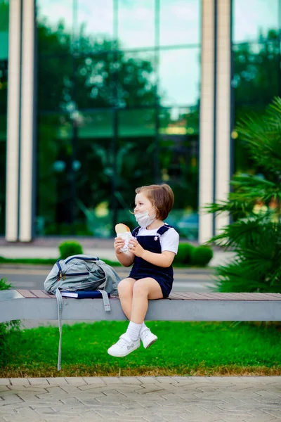 Een Klein Schoolmeisje Buurt Van School Zit Een Bank Eet — Stockfoto