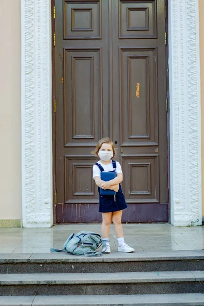 Krásná Holčička Školačka Stojí Během Dne Dveří Školy Maskou Tváři — Stock fotografie