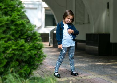 Güzel küçük bir kız, liseli bir kız, öğleden sonra okulun yanında, şık bir okul üniforması içinde.