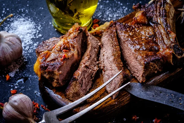 Bife grelhado fatiado em uma tábua de corte . — Fotografia de Stock