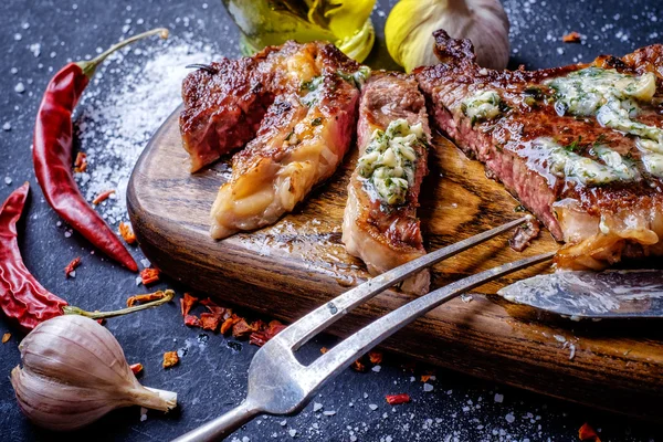 Gegrilltes Steak in Scheiben geschnitten auf einem Schneidebrett. — Stockfoto