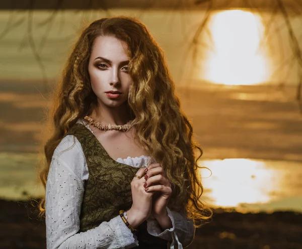 Menina com cabelo ondulado longo no pôr do sol . — Fotografia de Stock