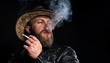 Elinde sigara olan kovboy şapkalı adam