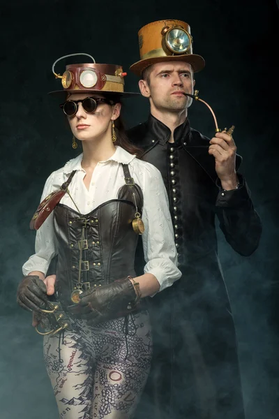 Steampunk paar. Man met een pijp en een meisje met bril en h — Stockfoto