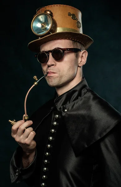 Steampunk man in a hat smoking a pipe. — Stock Photo, Image