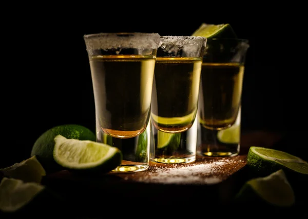 Meksykański Gold Tequila z cytryna i sól na drewnianym stole — Zdjęcie stockowe