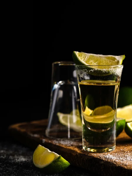 Tequila messicana in oro con lime e sale su tavola di legno — Foto Stock