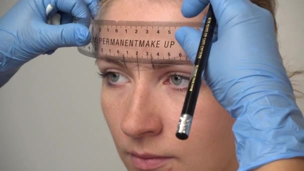 Microblading procedure. Master marks out customer's eyebrows. — Stock Video