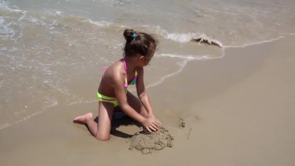 Kind spielt am Sandstrand des Meeres, kleines Mädchen an der exotischen tropischen Küste — Stockvideo