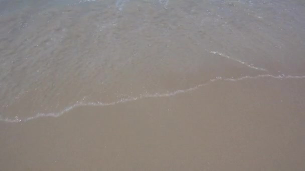 Tenger hullámai homokos strand felett. Homokos strand háttér texturált jön egy megy vissza a tenger hullámok