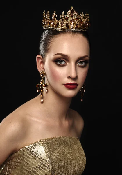 Beautiful brunette girl with a golden crown, earrings and profes — Stock Photo, Image