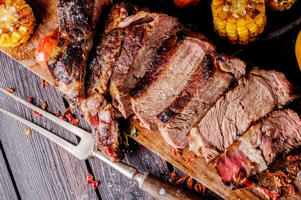 Bife grelhado fatiado em uma tábua de corte . — Fotografia de Stock