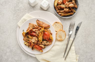 Patates ve domatesli kızarmış domuz eti.