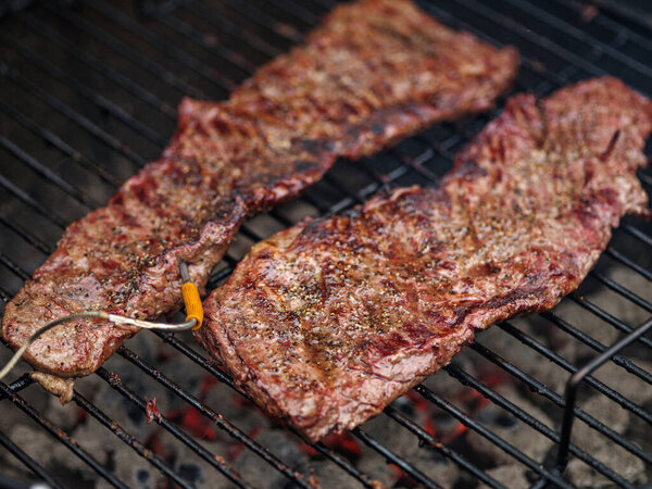 Hanging tender or onglet steak of beef on the grill. Grilling meat. BBQ. Selective focus. Close up.