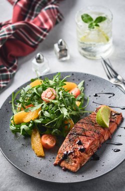 Roka salatası, vişneli domates ve portakallı sıcak füme somon. Sağlıklı beslenme