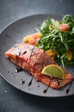 Roka salatası, vişneli domates ve portakallı sıcak füme somon. Sağlıklı beslenme