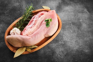 Raw cow tongue with greenery, garlic and dry peppers, close up, top view, high angle