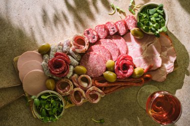 Zeytin ve yeşillikli et tabağı ahşap bir tahtada geleneksel İspanyol tapası olarak servis ediliyor. Jambon, salam ve Hamon seçimi. Et antipasto tabağı