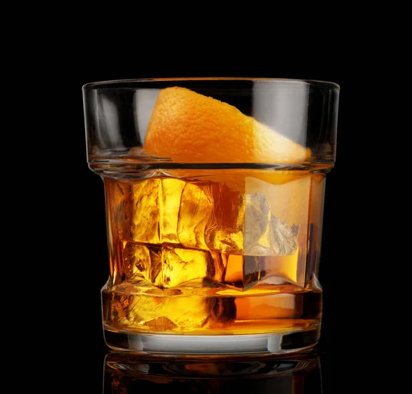 黒を基調とした氷とオレンジの皮を持つウイスキーのグラス — ストック写真