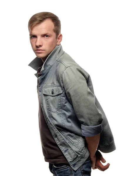 Porträt eines selbstbewussten jungen Mannes in Jeansjacke auf weißem Bac — Stockfoto