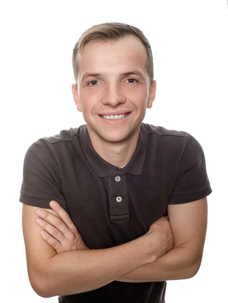 Un joven con una sonrisa, de pie con los brazos cruzados sobre un blanco —  Fotos de Stock