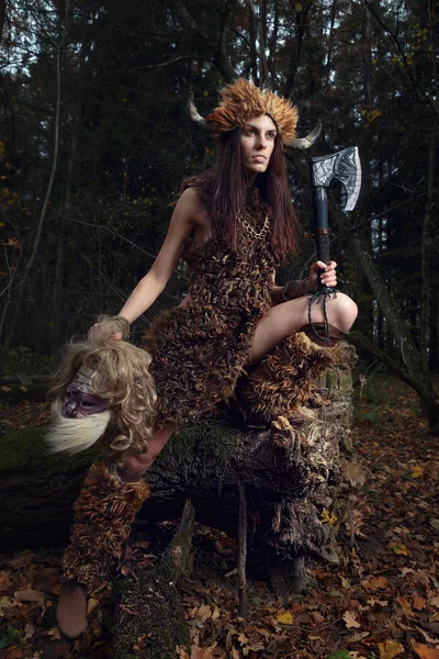 De oude vrouw in het bos met een bijl in zijn hand. — Stockfoto