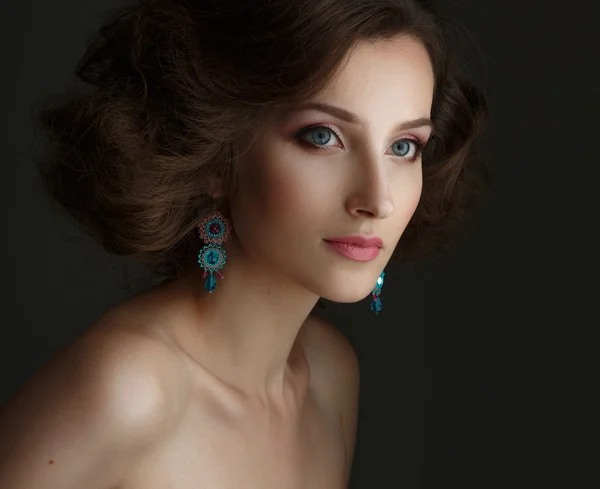 Portrait of beautiful young girl in earrings. — Stock Photo, Image