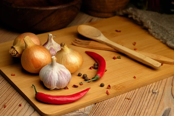 Onions, garlic and chili on a wooden table. — Stock Photo, Image