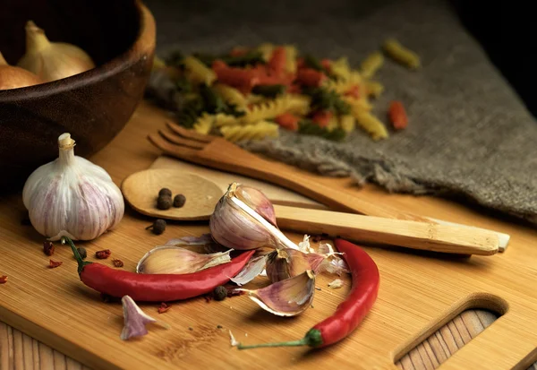 Spaghetti, Onions and garlic and on a wooden table. — Stock Photo, Image