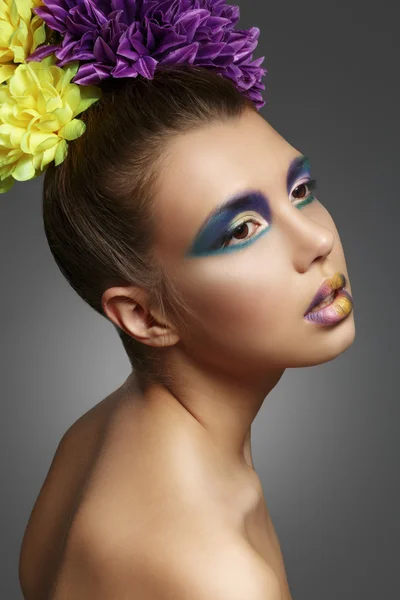 Kleurrijke make-up. Prachtige model met een boeket van bloemen in th — Stockfoto