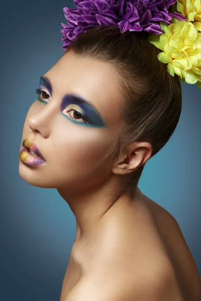 Maquiagem colorida. Modelo bonito com um buquê de flores em th — Fotografia de Stock