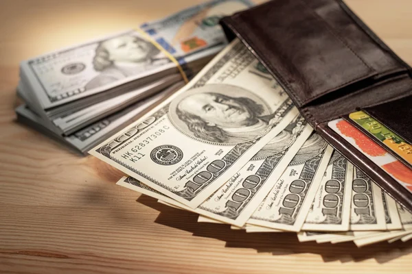 Brown Wallet with credit cards and dollar banknotes over wooden — Stock Photo, Image