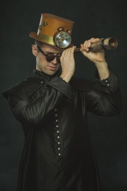 Teleskopla bakarak uzun bir ceket erkekte Steampunk.